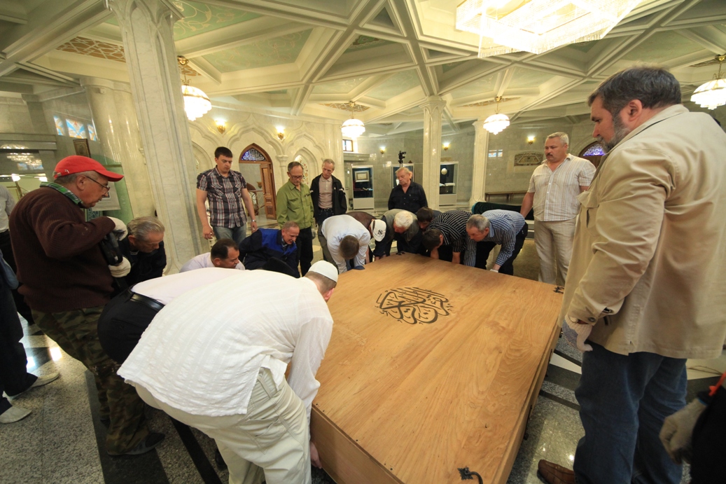 Огромный Коран поднимают все вместе